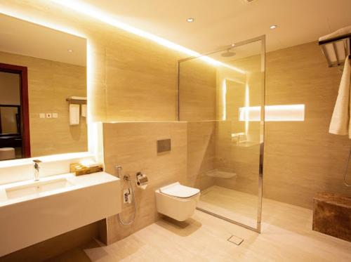 a bathroom with a toilet and a sink and a shower at فندق قمة البستان in Quai