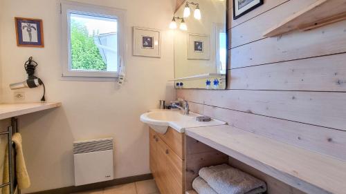 een badkamer met een wastafel en een houten muur bij Au lieu dit La Passe , Villa individuelle de plain pied, avec beaucoup de charme in La Couarde-sur-Mer