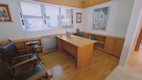 an office with a desk with a lamp and a chair at STAY Sunset Palazzo in Tala