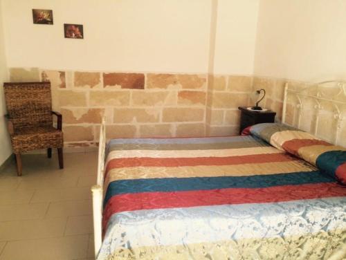 a bedroom with a bed and a chair at Tenuta Annibale in Leverano