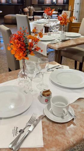 a table with plates and glasses and flowers on it at Hotel Rural Peñalabra in Cervera de Pisuerga