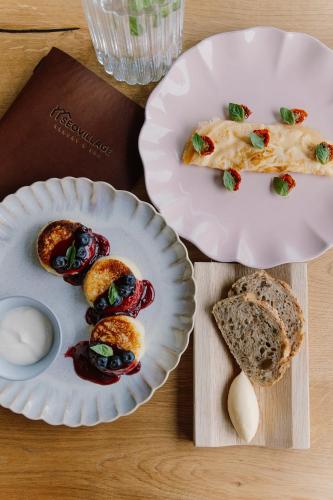 einen Tisch mit zwei Teller Essen und Brot in der Unterkunft SEOVILLAGE Resort & Spa in Ķeipene