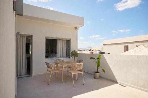 a patio with a table and chairs on a balcony at Cityloft Avenue in Mastambás