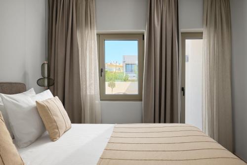a bedroom with a white bed and a window at Cityloft Avenue in Mastambás