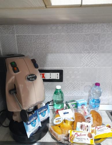 una macchinetta del caffè seduta su un bancone con cibo e bevande di La Dimora Di Bruna a Napoli