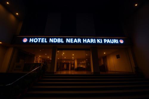un hall d'hôtel la nuit avec une enseigne dessus dans l'établissement Hotel NDBL Near Hari Ki Pauri Haridwar, à Haridwar