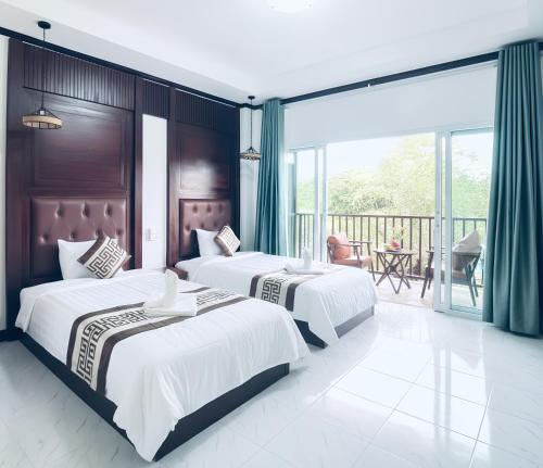 - 2 lits dans une chambre d'hôtel avec balcon dans l'établissement Intimate Riverside Resort Vang Vieng, à Vang Vieng