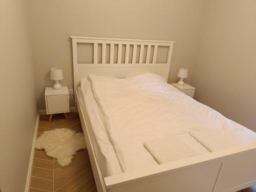 a bedroom with a white bed with two night stands at Apartament Ustrońska Jodełka z Balią i Ogrodem-Nadrzeczna in Ustroń