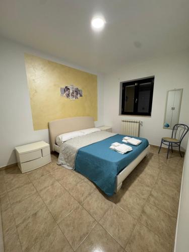 a bedroom with a bed and a table and a chair at Casa Vacanze Ginevra & Carlotta Villaggio RIVAZZURRA POLICORO in Policoro