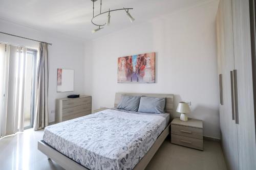 a white bedroom with a bed and a window at Spacious Seafront 3-Bedroom Apartment in Sliema SV 3 in Sliema