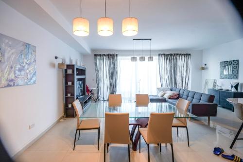 a living room with a glass table and chairs at Spacious Seafront 3-Bedroom Apartment in Sliema SV 3 in Sliema