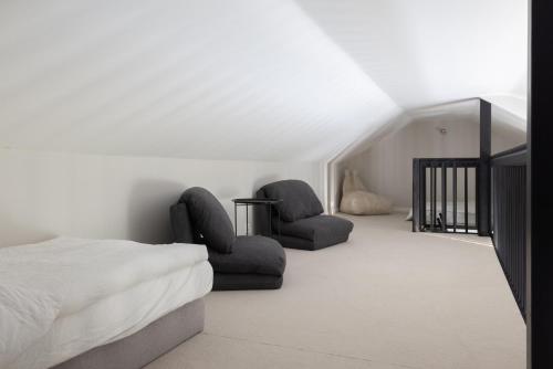 a bedroom with two chairs and a bed at Villa MiaEmilia B in Espoo