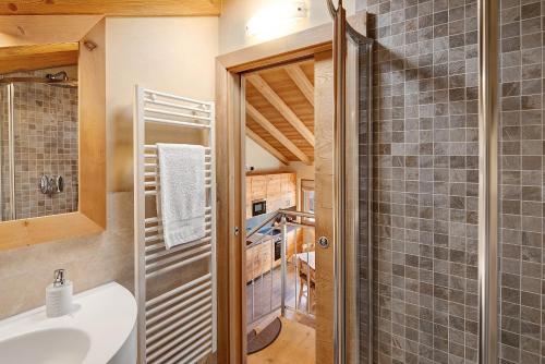 un baño con ducha y lavabo en Livigno Wooden House, en Livigno