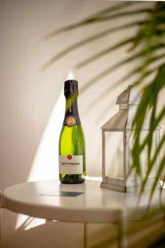 a bottle of wine sitting on a table next to a lamp at Hôtel Porte Mars - Reims Gare Centre Arena in Reims