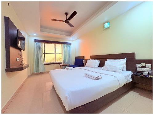 a bedroom with a large white bed with a ceiling fan at Rooftop Sea View Hotel The Shivalik Premium Deep Ganga Inn Near Jagannath Temple- Lift # Parking Facility # Fully Air Conditioning Premium Rooms-Best Premium Hotel In Puri in Puri
