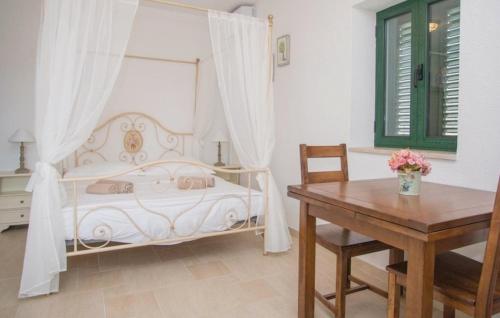 a bedroom with a white bed and a wooden table at Villa Monteneze by Villas Guide in Zagvozd