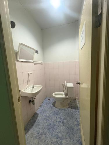 a bathroom with a toilet and a sink at อู๊ดดี้บริการห้องพัก in Nong Prue