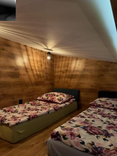 deux lits dans une chambre aux murs en bois dans l'établissement Odlotowe noclegi, à Chełmno