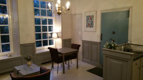una camera con tavolo, sedie e finestre di De olde banck a Stavoren