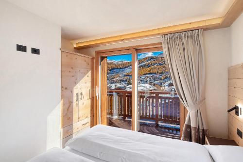 Un dormitorio con una cama y una ventana grande. en Livigno Wooden House, en Livigno