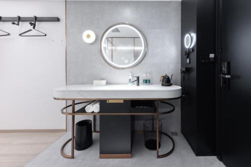 a bathroom with a white sink and a mirror at Atour Light Hotel Shenzhen Guanlan Sany Cloud in Shenzhen