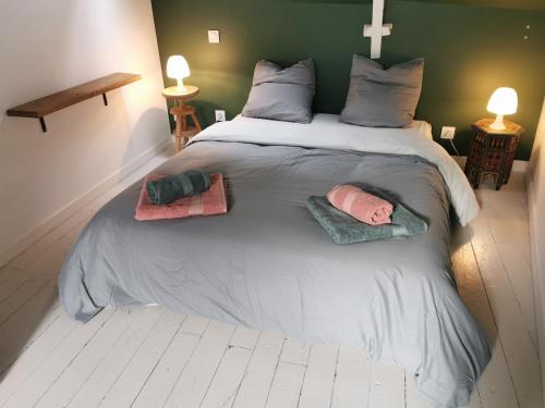 ein großes Bett mit zwei Kissen darauf in der Unterkunft Au Ptit Gauguin in Pont-Aven