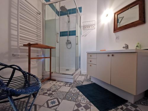 ein Badezimmer mit einer Dusche, einem Waschbecken und einem Stuhl in der Unterkunft Au Ptit Gauguin in Pont-Aven