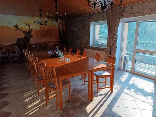 une salle à manger avec une grande table et des chaises en bois dans l'établissement Chata Dolinka Gápel, à Valaská Belá