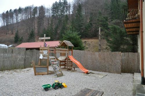 une aire de jeux avec un module de jeu et une clôture en bois dans l'établissement Chata Dolinka Gápel, à Valaská Belá
