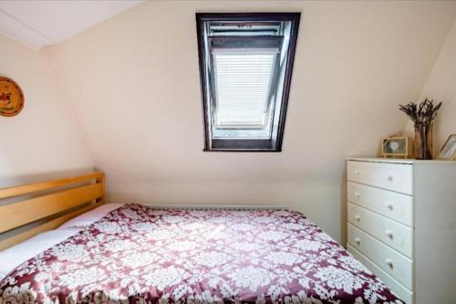 a small bedroom with a bed and a window at A home away from home in London