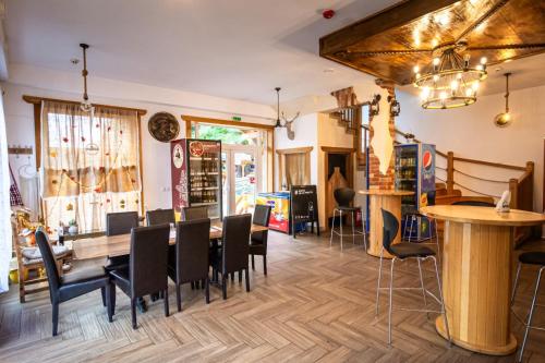 a restaurant with a dining room with tables and chairs at Pensiunea Popas Pop, Strambu-Baiut, Maramures in Băiuţ