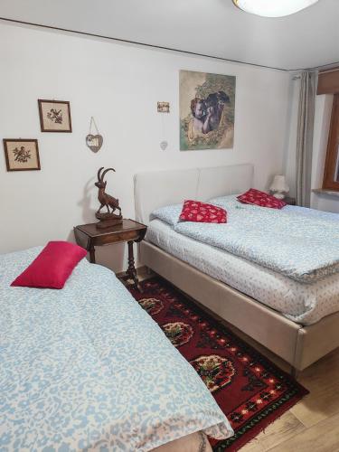 ein Schlafzimmer mit 2 Betten und roten Kissen darauf in der Unterkunft Maemorare - Caratteristico Bilocale in Casetta Indipendente in Challand Saint Anselme