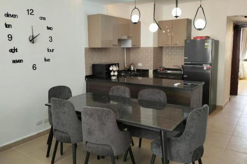 a kitchen with a table with chairs and a refrigerator at 2 Bed Chalet Sleeps 4 Free Parking & Balcony in Ain Sokhna