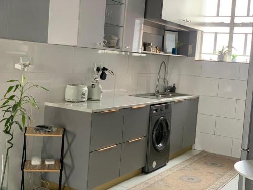 een keuken met een wasmachine en een wastafel bij Moro Rest in Windhoek