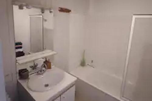 a white bathroom with a sink and a mirror at 3 Bed - Sleeps 8 - Mountain View - Balcony - Pets in Saint-Béat