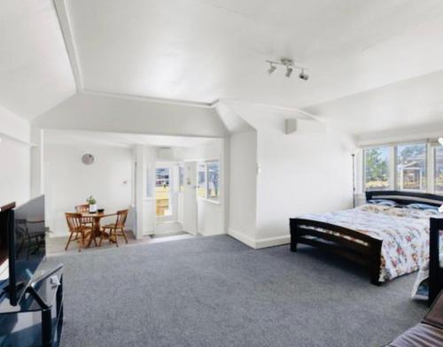 a bedroom with a bed and a dining room with a table at Giggly Nest in New Plymouth