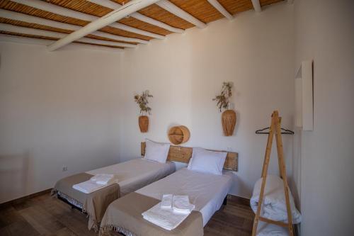 a bedroom with two beds and a wooden ceiling at Vinhas Douradas in Moura