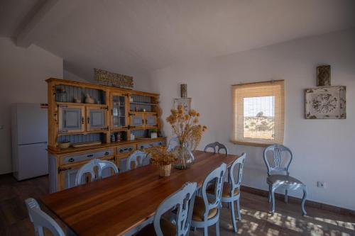 a dining room with a wooden table and chairs at Vinhas Douradas in Moura