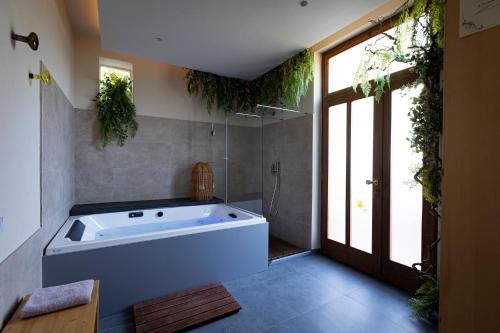a large bath tub in a bathroom with plants at La Camelia Bianca B&B in Lerici