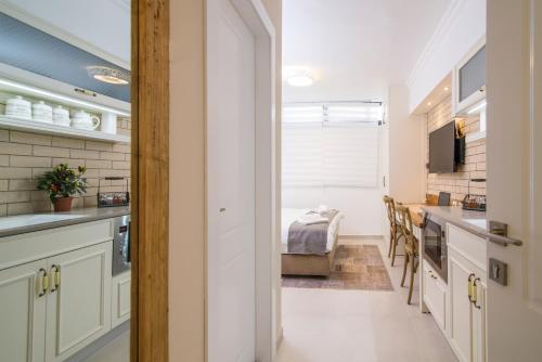 a kitchen with white cabinets and a dining room at HaBaitBe Matityahu By Domus in Beer Sheva