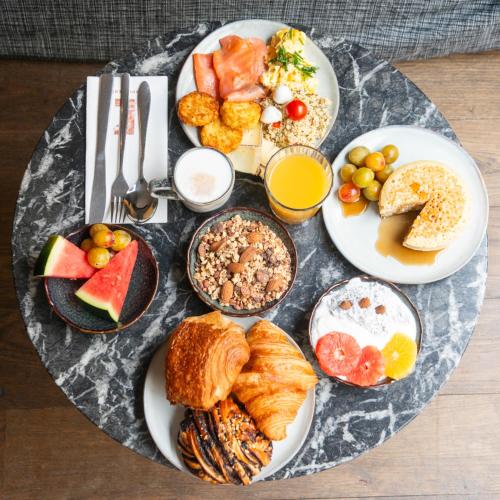 a plate of breakfast foods on a table at L'Imprimerie Hôtel in Clichy