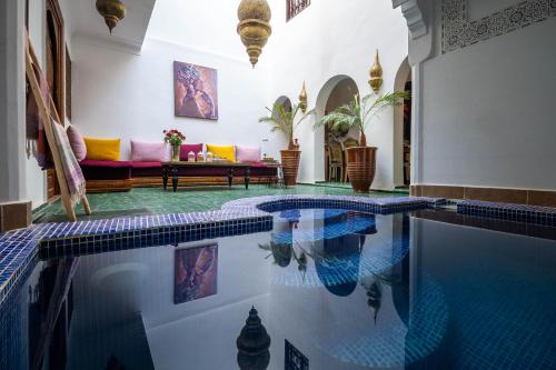 a swimming pool in a house with a living room at Riad Dekkak - Traditional Private Riad in Marrakesh