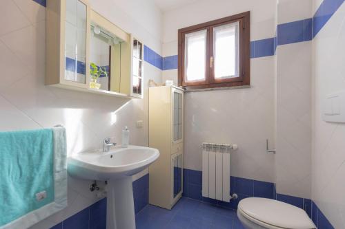 a bathroom with a sink and a toilet and a window at Appartamento ElbaBlu by ElbaSummer Tour Operator in Lacona