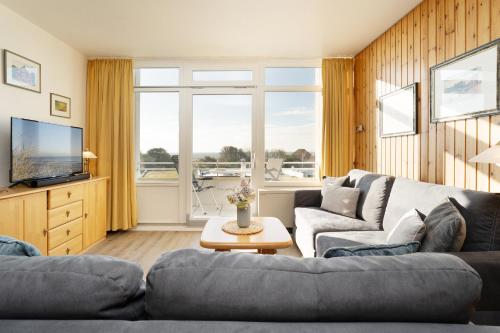 a living room with a couch and a tv at Strandhaferweg 7 Möwenoase in Burgtiefe auf Fehmarn 