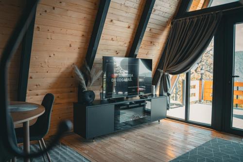 a living room with a flat screen tv on a stand at Oaza mira HaDaNa in Tihovići