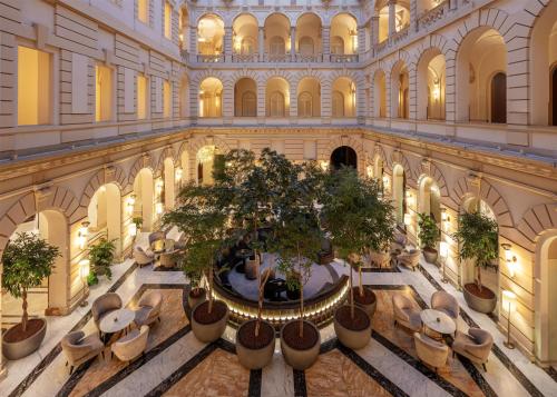 an indoor mall with a tree in the middle at Anantara New York Palace Budapest - A Leading Hotel of the World in Budapest