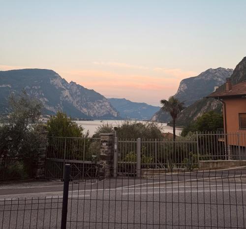 a fence with a view of the water and mountains at Casa Imelde al lago in Onno