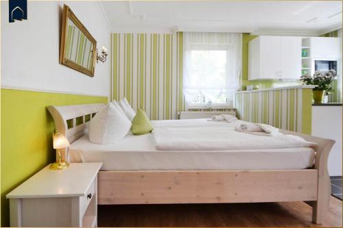 een slaapkamer met een groot bed met witte lakens bij Haus Lindenstraße (051) An den Linden in Heringsdorf