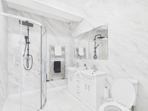 a bathroom with a shower and a toilet and a sink at Harbour Haven Steps from Torquay Port in Torquay