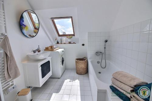 a bathroom with a tub and a sink and a toilet and a shower at De rulinen in Saint-Clet